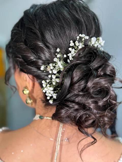 Textured bridal updo with delicate white floral accents