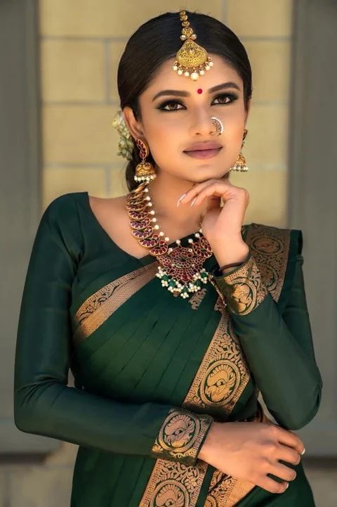 Green saree bridal portrait with gold jewellery and defined makeup