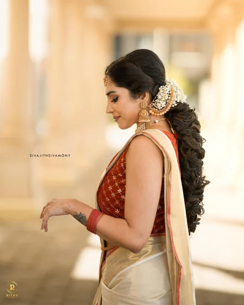 Long textured bridal hairstyle with white flowers and an ivory saree