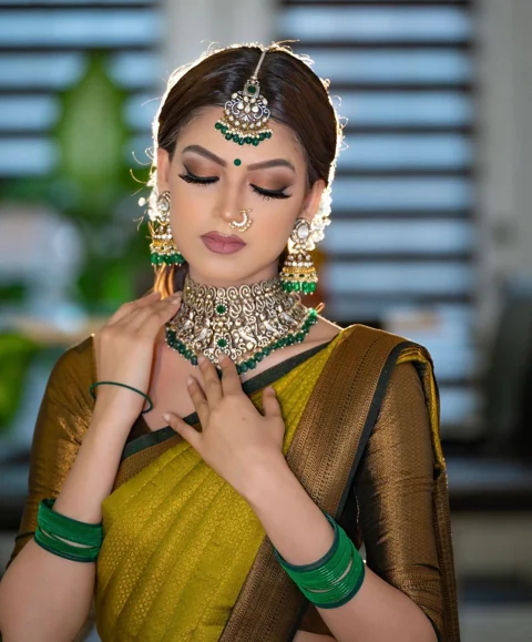 Olive gold bridal saree with emerald and pearl jewellery styling